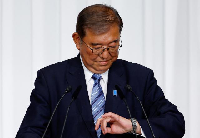 Japanese Prime Minister and leader of the ruling Liberal Democratic Party LDP Shigeru Ishiba looks at his watch as at the partys headquarters in Tokyo Oct 28 2024 Reuters-Yonhap