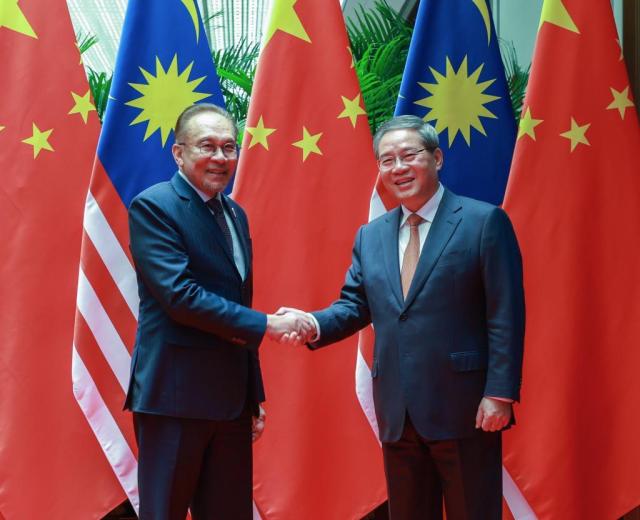 Chinese Premier Li Qiang shakes hands with Malaysian Prime Minister Anwar Ibrahim in Shanghai China onNov 5 2024 Xinhua-Yonhap