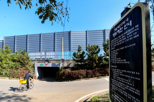 A resident on a bicycle passes by a development restriction sign in a greenbelt area in Seocho-gu Seoul on Nov 7 2024 AJP Kim Dong-woo