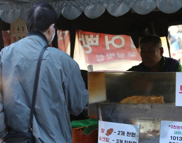 A person buys bungeoppangfish-shaped bun a Korean winter street snack in Seoul Nov 7 2024 AJP Han Jun-gu