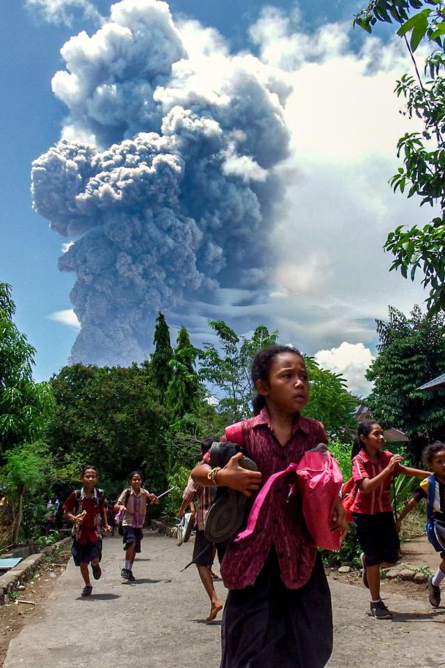 Schoolchildren run during the eruption of Mount Lewotobi Laki-Laki on Nov 7 2024 AFP-Yonhap