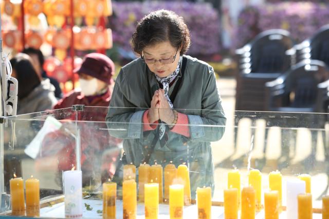 A visitor prays in front of a candle for students success on the College Scholastic Ability Test at Jogyesa in Seoul Nov 11 2024  AJP Han Jun-gu