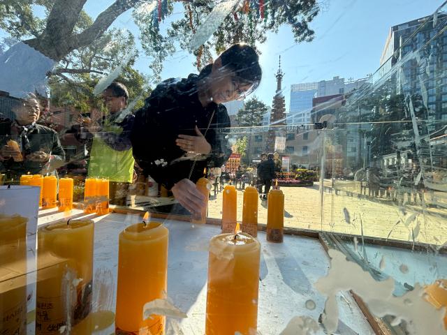 A visitor lights a candle to pray for students success on the College Scholastic Ability Test at Jogyesa Temple in Seoul Nov 11 2024  AJP Han Jun-gu
