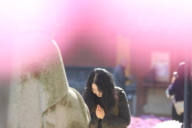 A visitor prays in front of a Buddha statue for students success on the College Scholastic Ability Test at Jogyesa Temple in Seoul Nov 11 2024  AJP Han Jun-gu