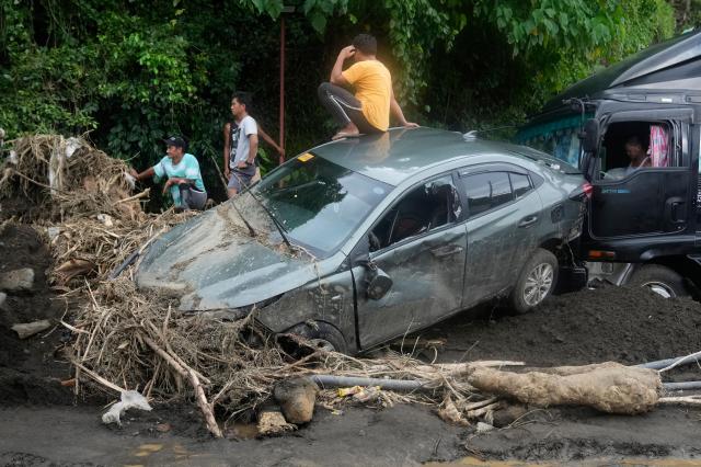 A man sits on a damaged car after a landslide in Philippines Oct 26 2024 AP-Yonhap