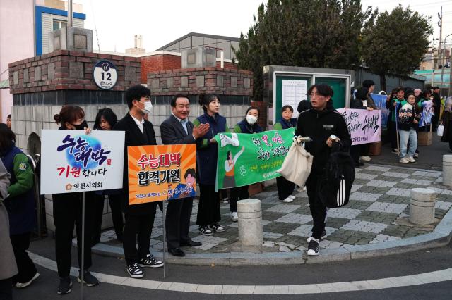 2025학년도 대학수학능력시험일에 수험장에서 수험생을 응원하고 있는 영천시의회 의원들과 의회 직원들 모습사진영천시의회