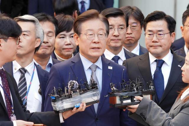 Lee Jae-myung leader of the Democratic Party who is facing charges of making false statements under the Public Official Election Act speaks to reporters at the Seoul Central District Court in Seocho District Seoul after his first trial verdict on Nov 15 Yonhap