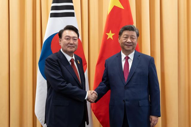 South Korean President Yoon Suk Yeol (left) shakes hands with Chinese President Xi Jinping before their summit in Lima on Nov. 15, 2024. Yonhap
