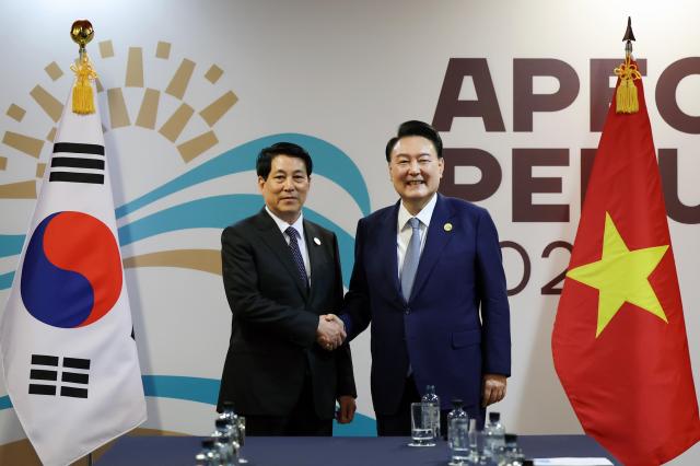 South Korean President Yoon Suk Yeol right shakes hands with Vietnamese President Luong Cuong ahead of their summit in Lima on Nov 16 2024 Yonhap