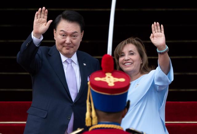 South Korean President Yoon Suk Yeol left and Peruvian President Dina Boluarte wave before their summit in Lima on Nov 16 2024 Yonhap