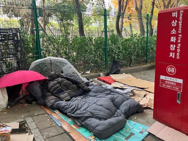 지난 14일 영등포 쪽방촌 인근에 거리 노숙인이 우산과 패딩을 펼쳐둔 채 자리를 떠나 있다 사진안수교 기자