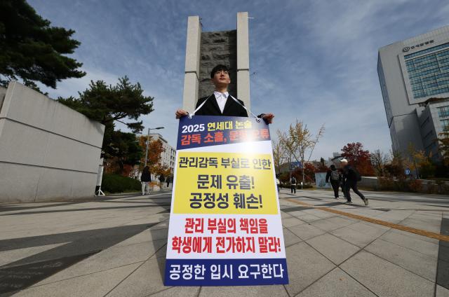 4일 서울 서대문구 연세대학교 정문 앞에서 연세대 재시험 집단소송의 후원자 중 한 명인 정모씨가 논술문제 유출 등을 규탄하며 1인 시위를 하고 있다 2024114 사진연합뉴스
 