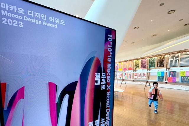 A child walks past posters at the Macao Design Award exhibition at Dongdaemun Design Plaza in Seoul on Nov 18 2024 AJP Kim Dong-woo