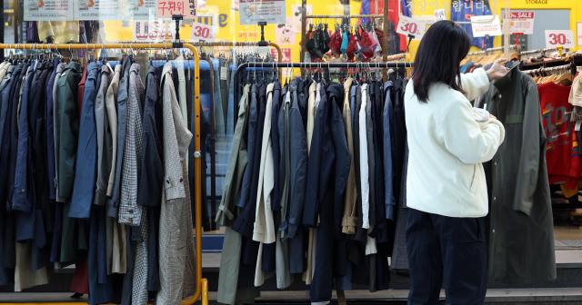 在首尔市内某家服装店，顾客正在挑选商品【图片来源 韩联社】