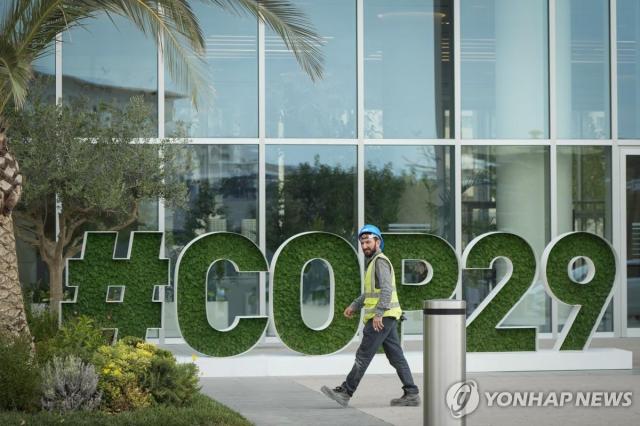 아제르바이잔 바쿠에 설치된 제29차 기후변화협약 당사국 총회COP29 안내판 앞으로 한 시민이 걸어가고 있다 사진연합뉴스