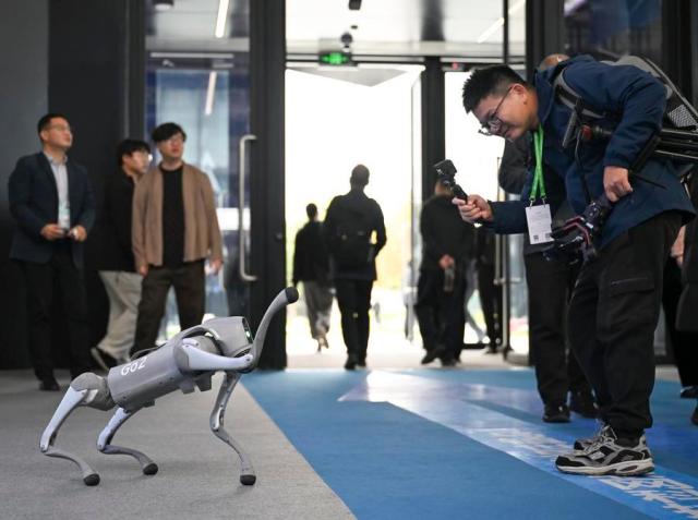 A visitor engages with a smart robotic dog at the Light of Internet Expo in Wuzhen eastern China on Nov19 2024 Xinhua-Yonhap