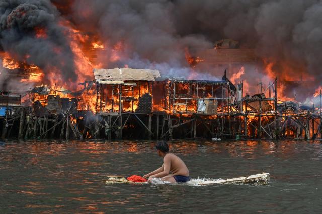 A man watches houses on fire at Tondo in Manila on Nov 24 2024 AFP-Yonhap