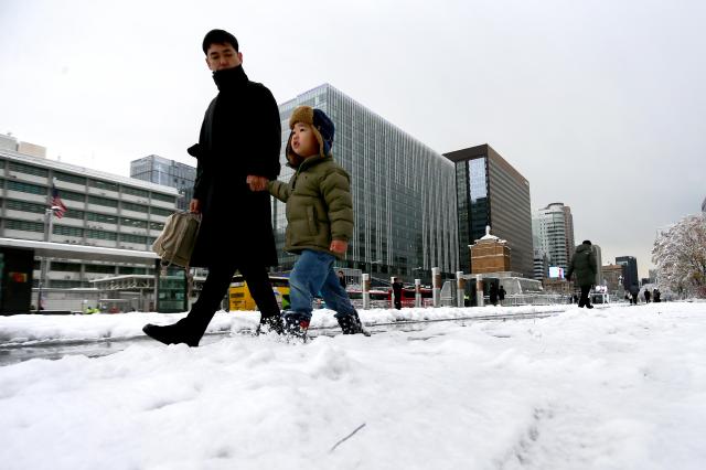 People walk through snow-covered streets in Seoul on Nov 27 2024 AJP Kim Dong-woo