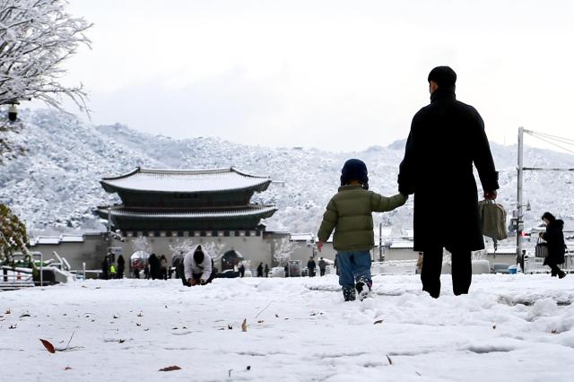 People walk through snow-covered streets in Seoul on Nov 27 2024 AJP Kim Dong-woo