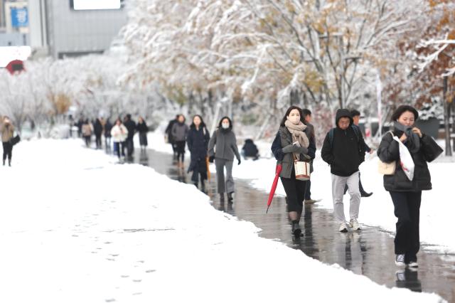 People walk through snow-covered streets in Seoul on Nov 27 2024 AJP Han Jun-gu