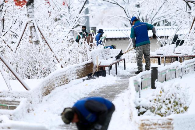 Snow removal workers clear a street in Seoul on Nov 27 2024 AJP Kim Dong-woo