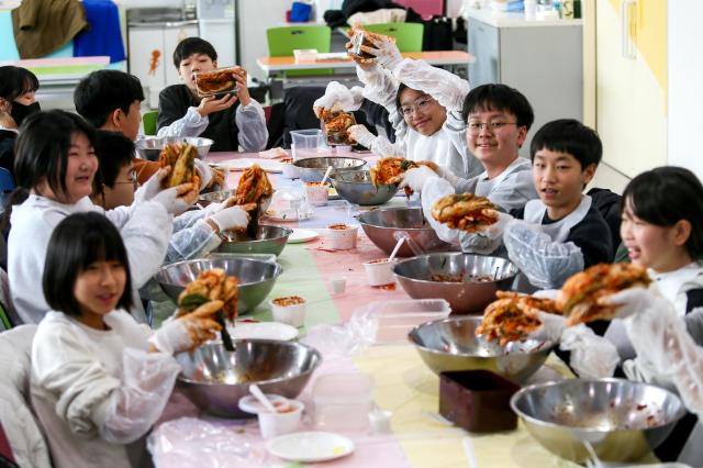 Students pose with kimchi they made during a traditional food education program at the National Folk Museum of Korea in Seoul on Nov 28 2024 AJP Kim Dong-woo