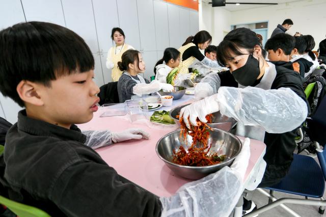 Students prepare ingredients during a traditional kimjang program at the National Folk Museum of Korea in Seoul on Nov 28 2024 AJP Kim Dong-woo