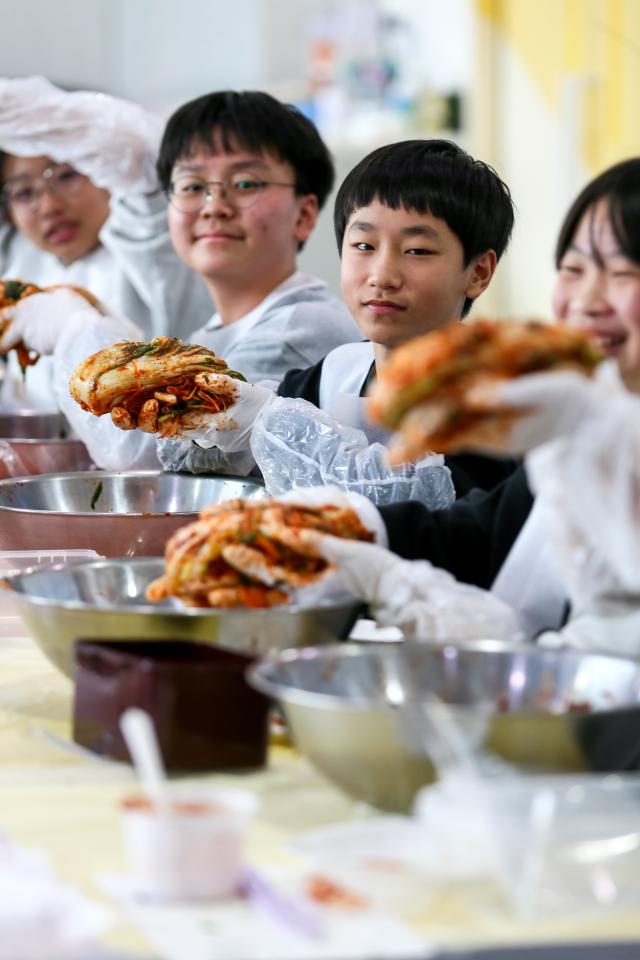 Students pose with kimchi they made during a traditional food education program at the National Folk Museum of Korea in Seoul on Nov 28 2024 AJP Kim Dong-woo