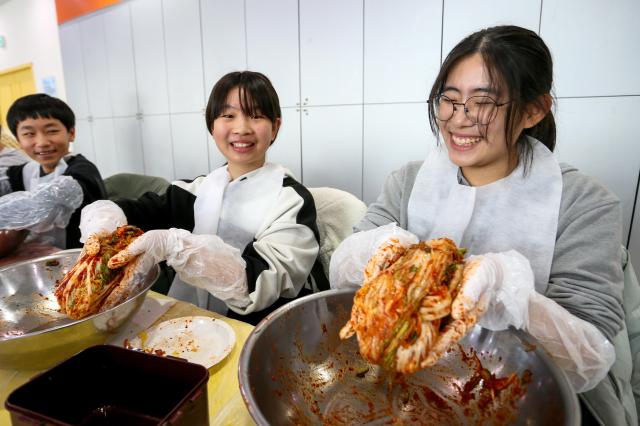 Students pose with kimchi they made during a traditional food education program at the National Folk Museum of Korea in Seoul on Nov 28 2024 AJP Kim Dong-woo