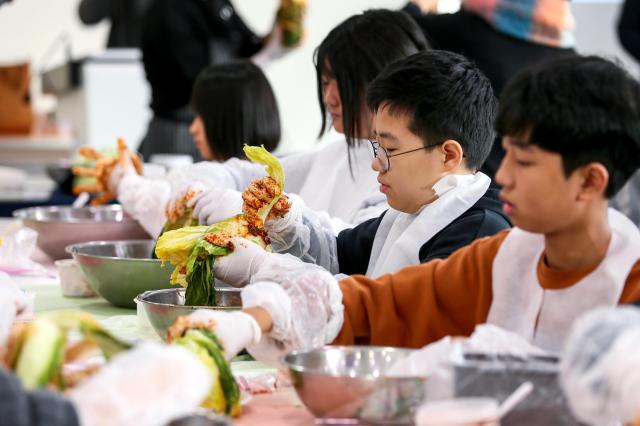 A student applies red pepper paste to cabbage leaves during a kimjang education program at the National Folk Museum of Korea in Seoul on Nov 28 2024 AJP Kim Dong-woo