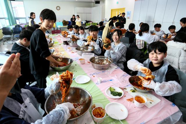 Students pose with kimchi they made during a traditional food education program at the National Folk Museum of Korea in Seoul on Nov 28 2024 AJP Kim Dong-woo