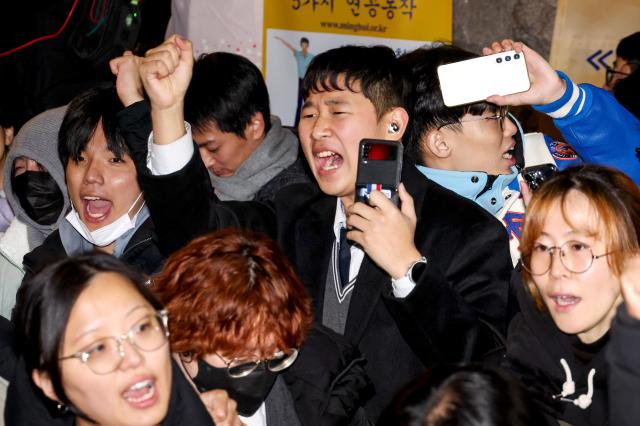 Citizens gathered in front of the National Assembly building in Yeouido cheer moments after the resolution to lift martial law was passed at about 100 am on Dec 4 AJP Kim Dong-woo