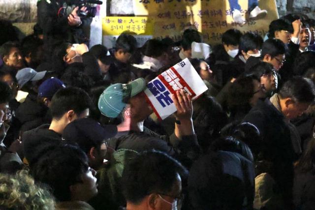 Citizens gathered in front of the National Assembly building in Yeouido cheer moments after the resolution to lift martial law was passed at about 100 am on Dec 4 AJP Han Jun-gu