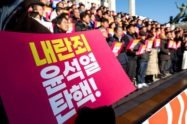 
Participants hold signs and chant slogans during a press conference by opposition parties and civic groups at the National Assembly in Seoul on Dec 6 2024 AJP Kim Dong-woo