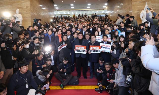 6일 오후 국회 로텐더홀에서 야당 의원들이 윤석열을 탄핵하라라고 적힌 손팻말을 들고 있다 사진연합뉴스