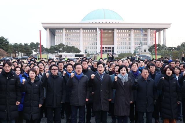 더불어민주당 이재명 대표를 비롯한 의원들이 윤석열 대통령 탄핵안 표결을 앞둔 7일 오전 서울 여의도 국회 앞에서 밤샘 농성을 한 시민들을 향해 감사 인사를 한 뒤 함께 구호를 외치고 있다 사진연합뉴스