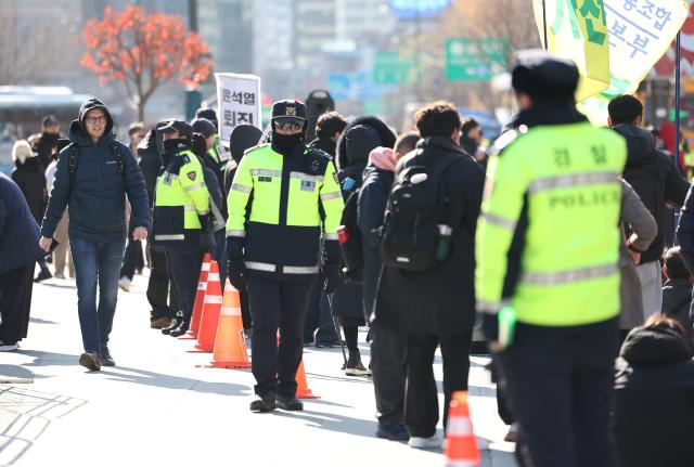 윤석열 대통령이 긴급 대국민 담화를 통해 비상계엄 해제를 선언한 4일 오전 서울 종로구 광화문광장에서 한 외국인 관광객이 계엄 반대 집회를 지켜보고 있다 2024124 사진연합뉴스