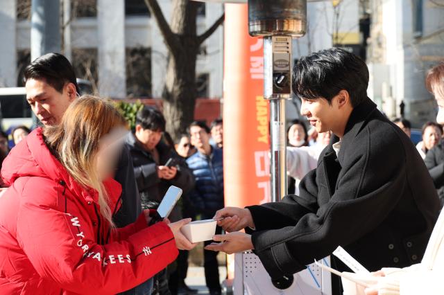 Lee Seung-gi distributes dumplings to visitors during the About Family movie release dumpling truck event in Seoul on Dec 10 2024 AJP Han Jun-gu