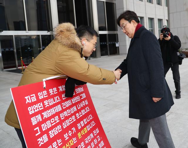 권성동 국민의힘 신임 원내대표가 13일 국회 본청 앞에서 탄핵 찬성을 호소하는 김상욱 의원과 악수하고 있다 사진연합뉴스