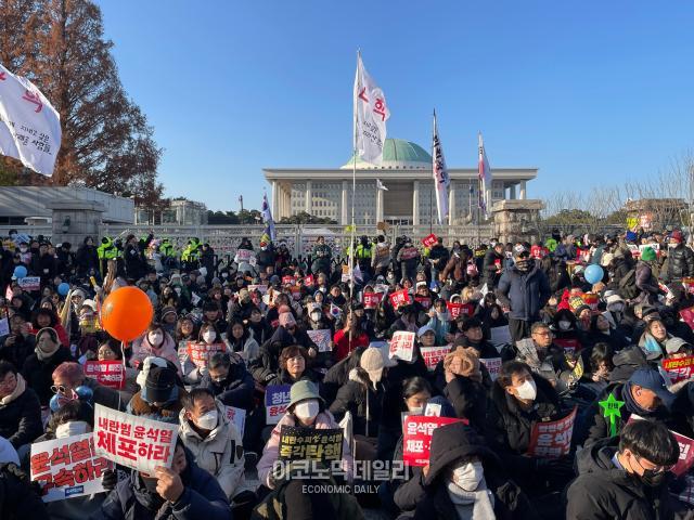 14일 서울 여의도 국회의사당 앞 사람들이 모여 윤석열 대통령 탄핵 시위를 진행하고 있다 사진 김은서 수습기자