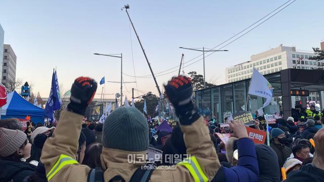 국회의사당역 앞에서 윤석열 대통령 탄핵 촉구 집회에 참여한 참가자가 14일  탄핵소추안 가결 발표를 듣고 만세하고 있다 사진김은서 수습기자