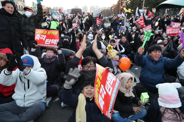 Civilians gathered near the National Assembly cheer on as they confirmed that President Yoons impeachment vote has been passed Dec 14 2024 AJP Han Jun-gu