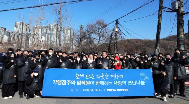 이디야커피 가맹점주들과 임직원들이 지난 18일 서울 강남구 구룡마을 일대에서 연탄 나눔 봉사활동을 진행하고 기념촬영을 하고 있다 사진이디야커피