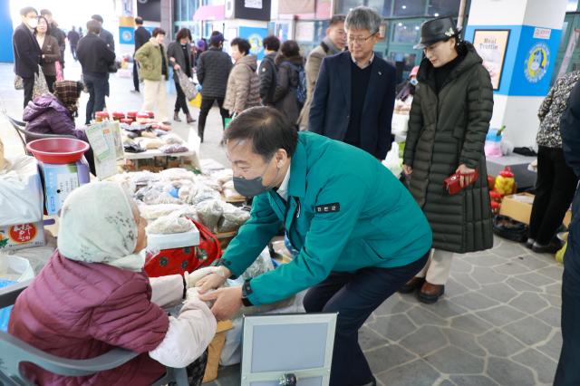 전춘성 진안군수가 19일 지역 화폐인 진안고원 행복상품권으로 장을 보며 상인들을 격려하고 있다사진진안군