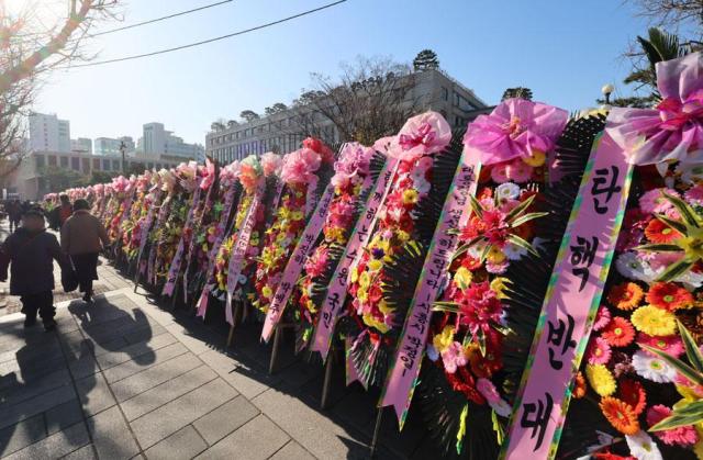 Pedestrian walk past flowers supporting President Yoon Suk Yeol outside the Constitutional Court of Korea in Jongno Seoul on Dec 17 2024 Yonhap