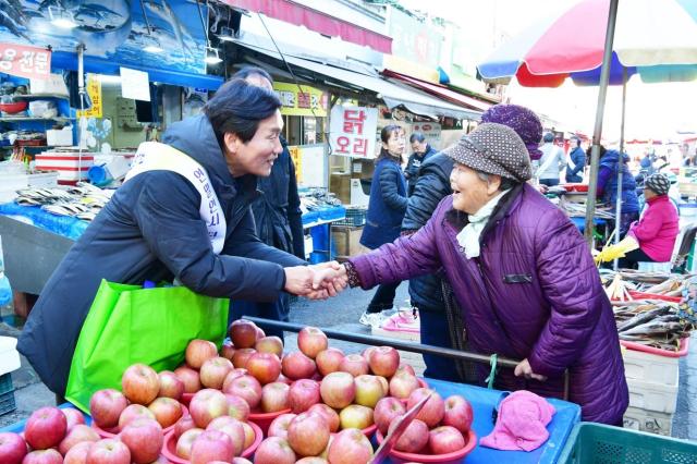 조현일 경산시장이 지역경기 활성화를 위해 경산 전통시장을 방문해 장을 보며 시장상인들을 격려하고 시민들에게 전통시장 이용을 당부하고 있다 사진경산시