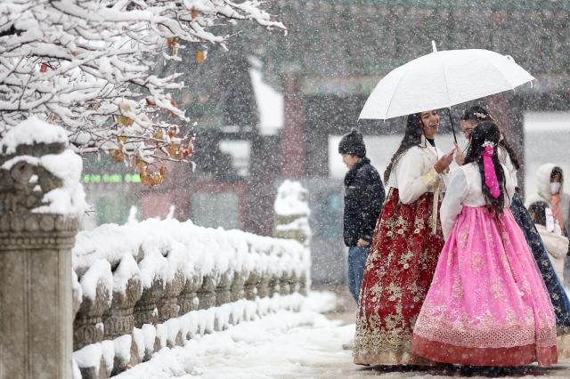 Du khách tham quan Gyeongbokgung trong ngày tuyết rơi ẢnhYonhap News