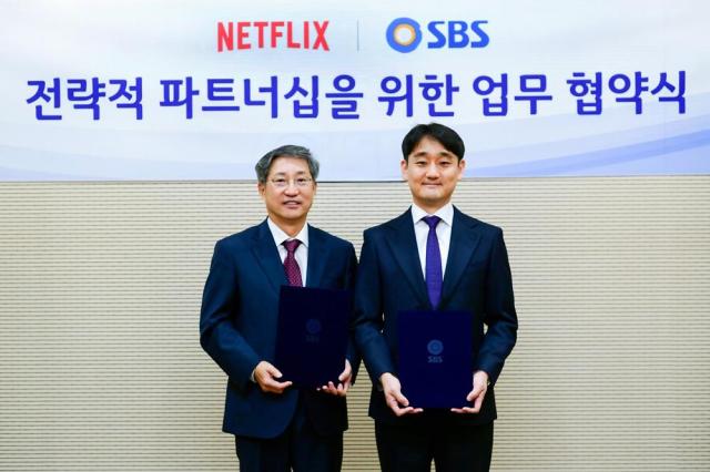 SBS CEO Bang Moon-shin left poses for a photo with Netflixs Vice President Kang Dong-han after signing a partnership on Dec 20 2024 Courtesy of SBS

