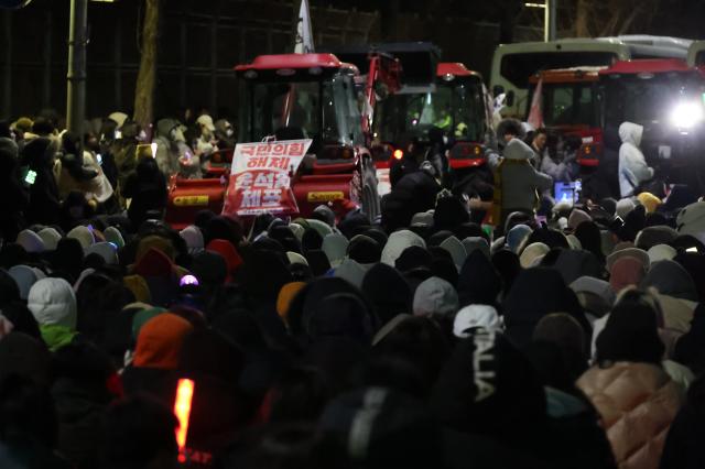 Farmers and protesters chant demanding the arrest of President Yoon Suk Yeol near Namtaeryeong Hill in Seoul Dec 22 2024 AJP Han Jun-gu