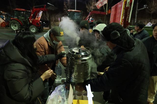 Volunteers distribute coffee and water to protesters near Namtaeryeong Hill in Seoul Dec 22 2024 AJP Han Jun-gu